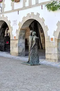Sculpture de couple devant arcades à La Bastide-Clairence